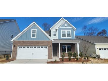 Charming two-story home featuring a brick facade, attached two-car garage, and a welcoming covered entryway at 143 Ella Claire Dr, York, SC 29745