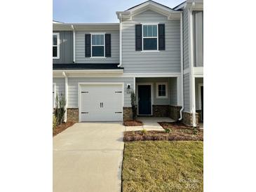 Two-story house with gray siding, white garage door, and landscaping at 1620 Village Grove Ln, Monroe, NC 28110