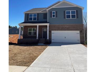 Charming two-story home with a welcoming front porch and a spacious two car garage at 107 Rustling Waters Dr, Mooresville, NC 28117