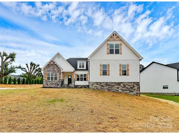 Inviting two-story home with stone accents, white siding, wood shutters, and manicured lawn at 2059 Parks Rd, Salisbury, NC 28147