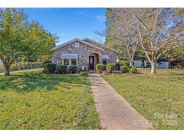 Charming stone ranch house with a well-manicured lawn and walkway at 713 Perkins St, Lowell, NC 28098