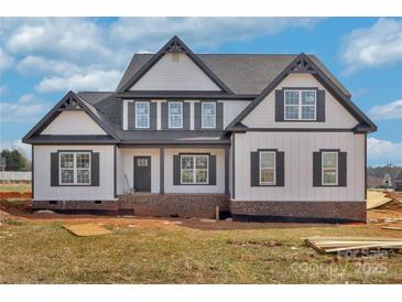 New two-story home featuring board and batten siding, a dark roof, and black framed windows under a bright blue sky at 2025 Parks Rd, Salisbury, NC 28147