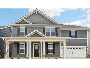Charming two-story home with gray siding, a covered front porch, and manicured landscaping at 317 Miramar Dr, York, SC 29745
