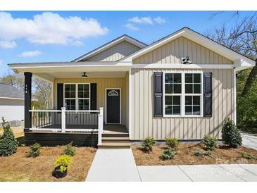 Charming home features a welcoming porch, black shutters, and well-maintained landscaping at 414 Clinton Ave, Lancaster, SC 29720