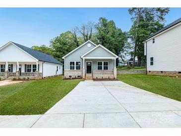 Charming single-story home features a well-manicured lawn and a welcoming front porch with brick accents at 602 Meadow Ave, Spencer, NC 28159