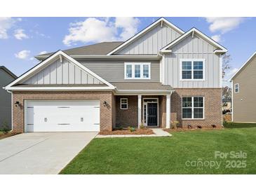 Two-story house with brick and siding, two car garage, and landscaped lawn at 219 E Warfield Dr, Mooresville, NC 28115