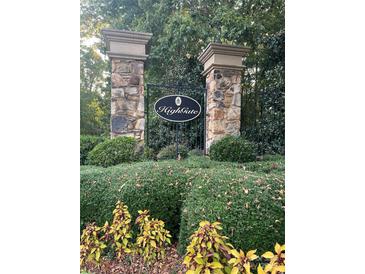 Stone pillar entrance to Highgate community, featuring lush landscaping and a decorative wrought iron gate at 2097 Kings Manor Dr # 53, Matthews, NC 28104