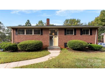 Brick ranch house with a landscaped lawn and walkway at 3327 Deerwood Dr, Gastonia, NC 28054