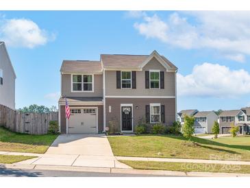 Two-story house with a two-car garage, an American flag, a well-kept lawn, and landscaping at 1197 Tangle Ridge Se Dr, Concord, NC 28025
