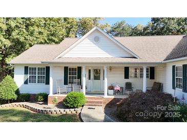 White house with a brown roof, front porch, and landscaping at 1499 Angela Ct, Lincolnton, NC 28092