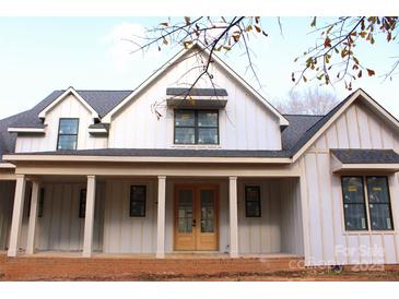 Charming new construction home featuring a covered front porch and double front doors at 104 Arbor Dr, Waxhaw, NC 28173