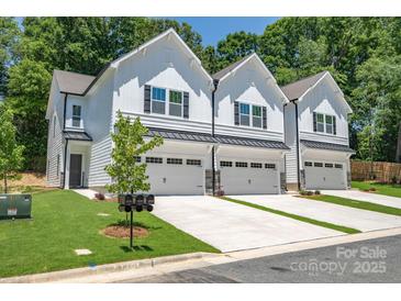 New construction townhomes featuring bright white exteriors and individual garages at 19761 Feriba Pl, Cornelius, NC 28031