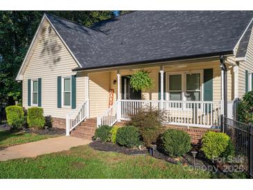 Inviting home featuring a charming front porch with white railings and well-maintained landscaping at 1000 Hunting Ave, Lincolnton, NC 28092