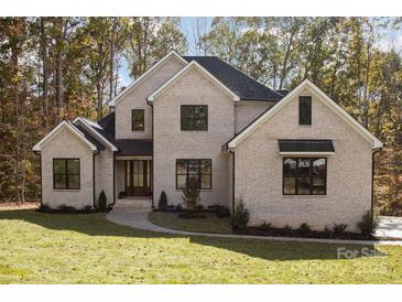 Beautiful two-story brick home featuring a manicured lawn, dark-framed windows, and a welcoming front entrance at 1025 Readsboro Dr # 11, Mt Ulla, NC 28125
