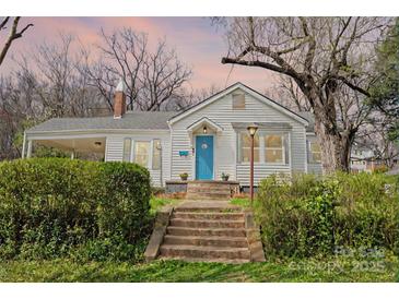 Charming home featuring a bright blue front door, inviting front porch, and well-maintained landscaping at 106 S Inman Ave, Bessemer City, NC 28016