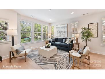 Bright living room featuring hardwood floors, many windows, modern decor, and comfortable seating at 2031 Belmont Terraces Ln # 6, Charlotte, NC 28205