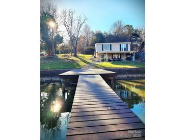 Waterfront home featuring a private wooden dock with direct access to the lake, beautiful landscaping and sunshine at 287 Ben Eller Ln, Taylorsville, NC 28681