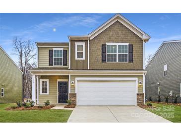 Charming two-story home featuring a two-car garage, black shutters, and manicured lawn at 110 Dorian Pl, Troutman, NC 28166