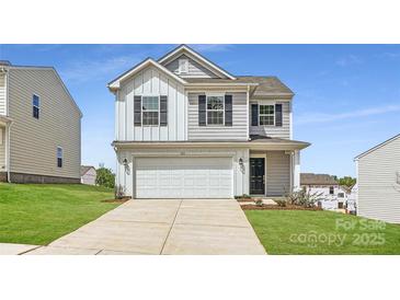 Charming two-story home featuring a two-car garage, gray siding, and a well-manicured lawn at 123 Dorian Pl, Troutman, NC 28166