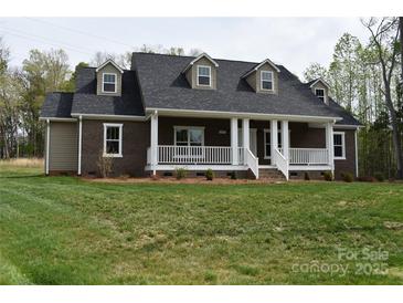 Charming brick home featuring a covered front porch with white columns and a well-maintained lawn at 1117 Shadowmoss Ct, Salisbury, NC 28147