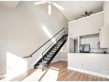 Open living area with loft, modern staircase, and hardwood floors at 115 E Park Ave # 419, Charlotte, NC 28203