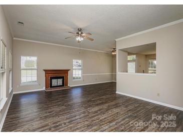 Bright living room features a fireplace, hardwood floors, and a ceiling fan at 14301 Beryl Ct, Pineville, NC 28134