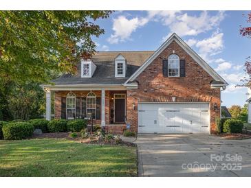 Beautiful brick home featuring a well-maintained lawn, mature landscaping, and a two-car attached garage at 1001 Hatton Ter, Fort Mill, SC 29707