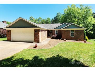 Charming single-story brick home featuring an attached two-car garage and a well-maintained front lawn at 2015 Pine Needle Ct, Gastonia, NC 28056