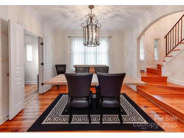 Elegant dining room featuring hardwood floors, a striking chandelier, and ample natural light at 501 River Oaks Ln, Charlotte, NC 28226
