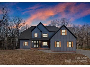 Stunning two-story farmhouse with gray siding, wood accents, and a welcoming front porch at 8508 Tirzah Church Rd, Waxhaw, NC 28173