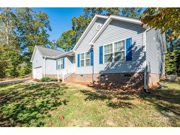 A light blue house is pictured with bright blue shutters with a well maintained lawn at 5039 Penn Rd, Iron Station, NC 28080