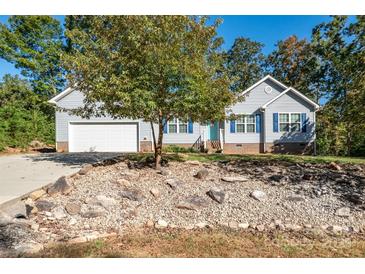 Charming single-story home features a well-maintained yard, light blue siding, and vibrant blue shutters at 5039 Penn Rd, Iron Station, NC 28080