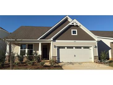 Inviting home with a two-car garage, stone accents, neutral siding, and a well-manicured front yard at 1032 Bull Dog Ln, Wingate, NC 28174