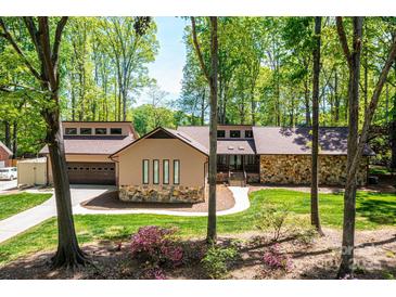 Ranch home with stone accents, two-car garage, and spacious backyard nestled among trees at 315 Camelot Dr, Salisbury, NC 28144