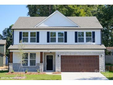 Charming two-story home featuring a gray roof, black shutters, and a two-car garage with stone accents at 48 Sherwood Nw Ct # Sw48, Concord, NC 28027