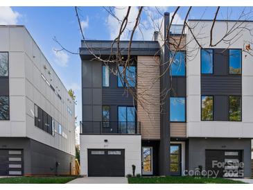 Modern three-story home featuring mixed material facade, black garage door, and a small balcony at 217 Keswick Ave, Charlotte, NC 28206