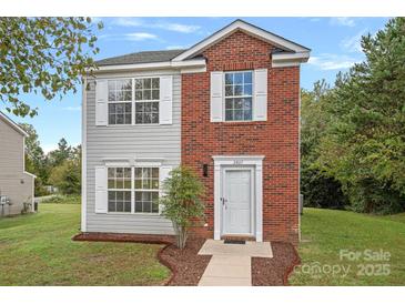 Brick two-story house with a gray-sided exterior and a white door at 2807 Station Sw Ln, Concord, NC 28025