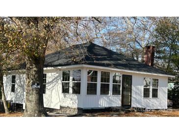 Charming white home with a new roof and windows, located on a partially wooded lot at 7608 Kershaw Camden Hwy, Kershaw, SC 29067