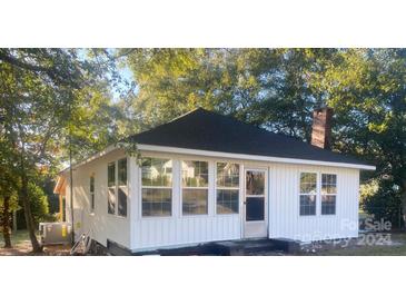 Charming white cottage with a sunroom and updated roof at 7608 Kershaw Camden Hwy, Kershaw, SC 29067