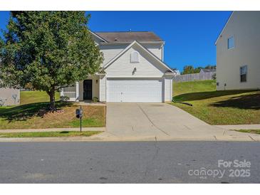 Charming two-story home with a two car garage, inviting front porch, and mature shade tree at 8228 Weeping Fig Ln, Charlotte, NC 28215