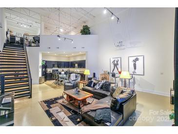 Spacious loft living room with high ceilings, modern furniture, and large windows at 929 Westmere Ave, Charlotte, NC 28208