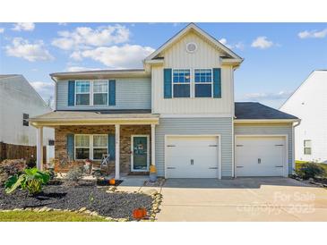 Charming two-story home features a two car garage, blue shutters and vinyl siding at 1176 Whitehall Hill Rd, York, SC 29745