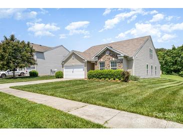 Charming home featuring manicured lawn, a two-car garage, brick accents, and lovely landscaping at 135 Anastasia Ln, Lincolnton, NC 28092