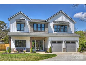 Beautiful two story home with white siding, brick accents, covered porch, and a two car garage at 571 Lyttleton Dr, Charlotte, NC 28211