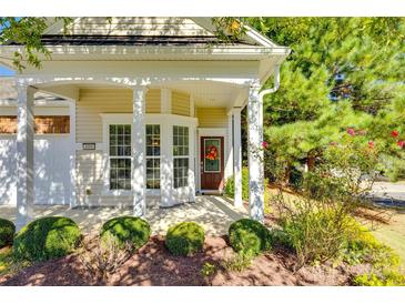 Inviting covered front porch with white columns, bay window, and a charming front door with decorative wreath at 4006 Trinity Ct, Indian Land, SC 29707