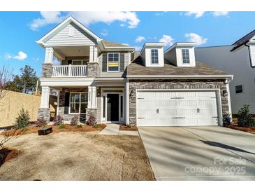 Two-story house with stone accents, a large garage, and a balcony at 5226 Verona Rd # 81, Charlotte, NC 28213