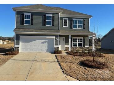 Two-story house with gray siding, white garage door, and landscaping at 11933 Cabera Ln, Midland, NC 28107