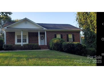 Charming single-story brick home with a well-manicured lawn and inviting front porch at 4000 Wilson Ln, Charlotte, NC 28206
