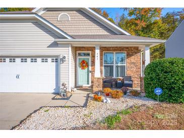 Beige house with stone accents, a two-car garage, and landscaping at 541 Settlers Grove Ln, Salisbury, NC 28146