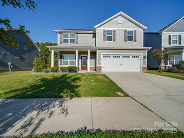 Charming two-story home featuring a well-manicured lawn and a two-car garage at 4342 Allenby Pl, Monroe, NC 28110